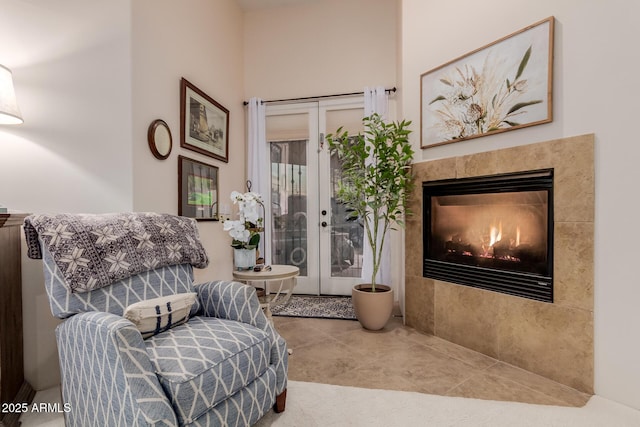 sitting room featuring a tile fireplace and french doors