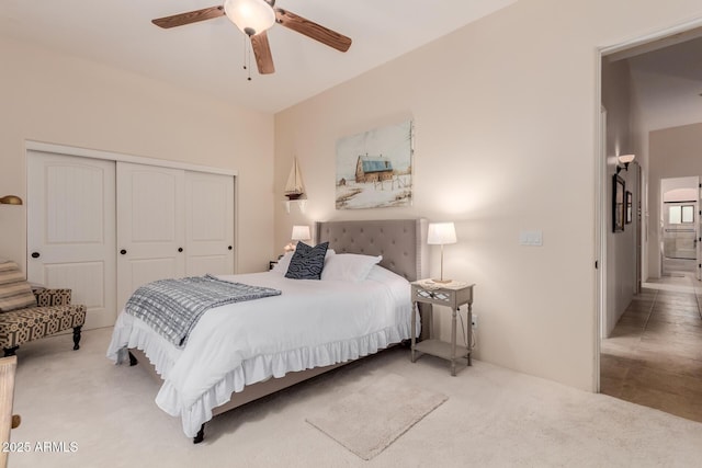 carpeted bedroom with ceiling fan and a closet