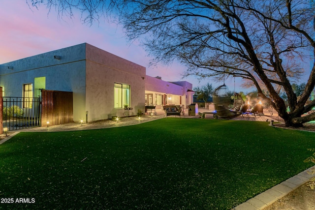 yard at dusk featuring a patio area