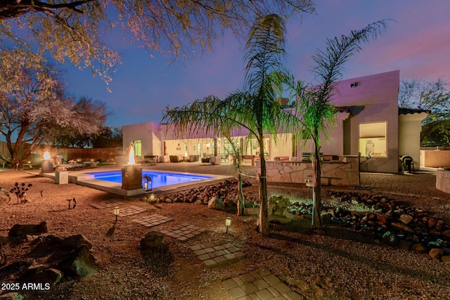 pool at dusk with a patio