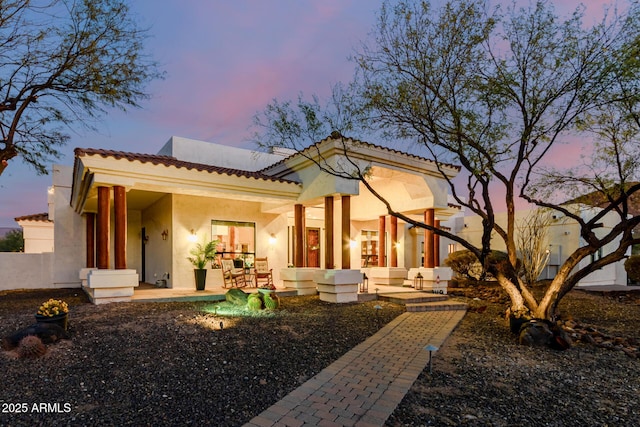 back house at dusk with a patio