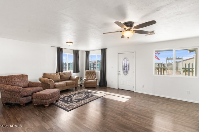 living room featuring ceiling fan and dark wood-type flooring