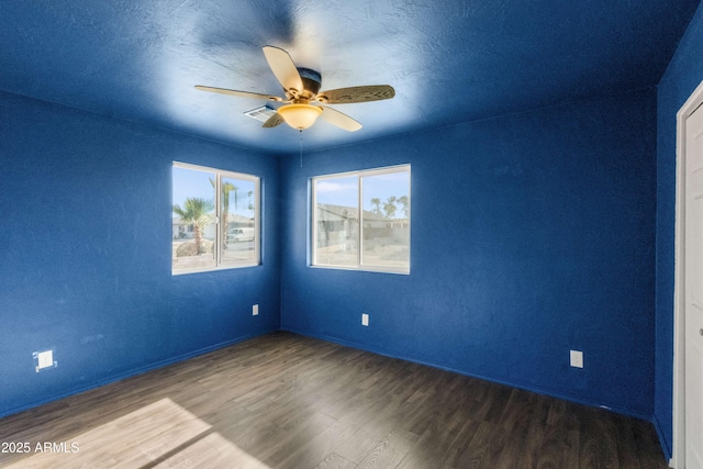 empty room with a textured ceiling, hardwood / wood-style flooring, and ceiling fan