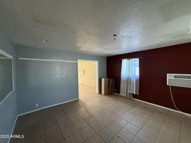 4310 N 42nd Pl, Phoenix, AZ 85018 - tiled spare room featuring a textured ceiling, an AC wall unit, and baseboards