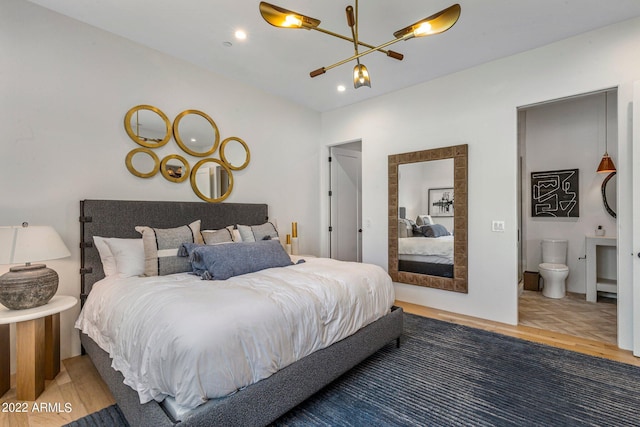 bedroom with recessed lighting, ensuite bath, an inviting chandelier, and wood finished floors