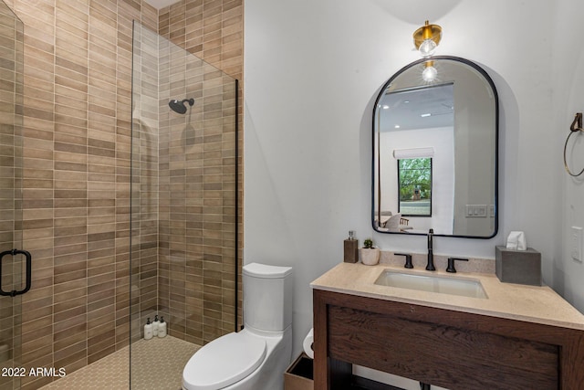 full bathroom with toilet, a stall shower, and vanity