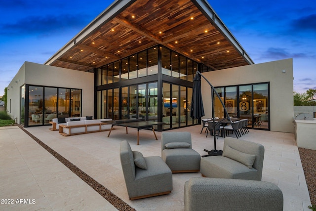 patio terrace at dusk with outdoor dining area and an outdoor hangout area