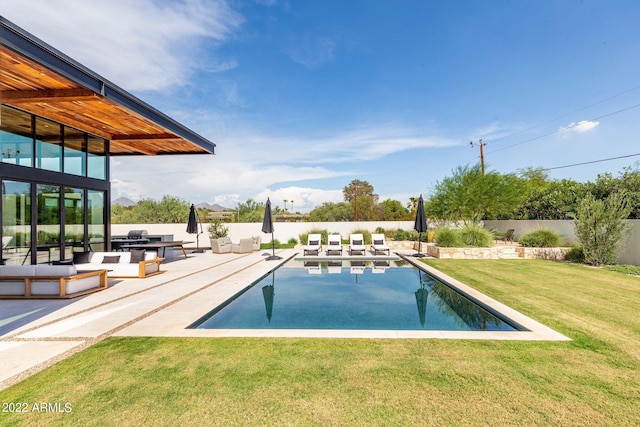 view of pool with a patio, a lawn, and a fenced backyard