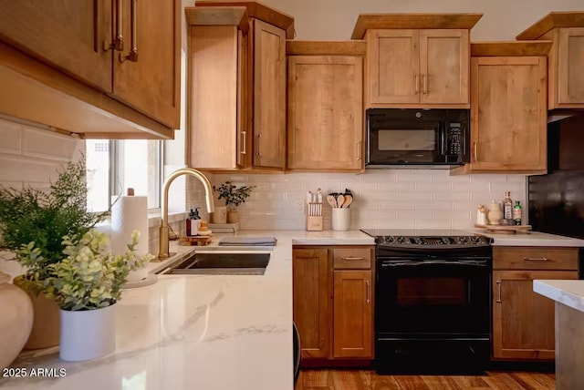 kitchen featuring backsplash, black appliances, and sink