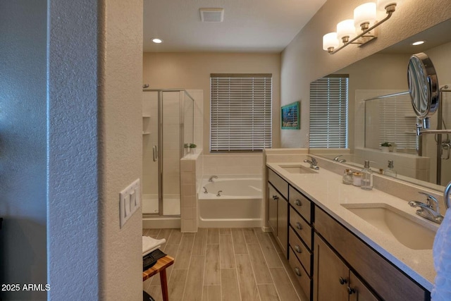 full bathroom featuring wood tiled floor, a garden tub, a sink, and a shower stall