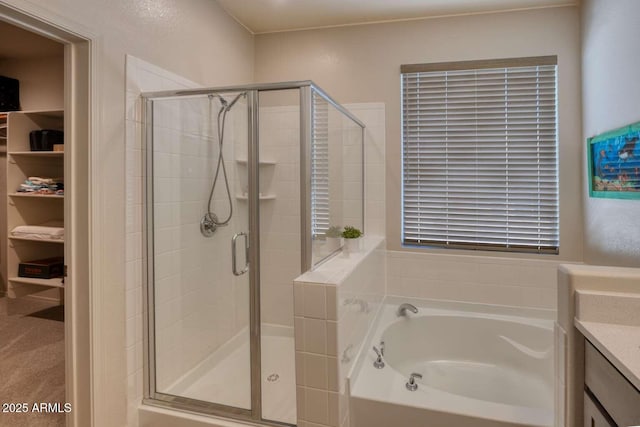 bathroom with a stall shower, vanity, and a bath