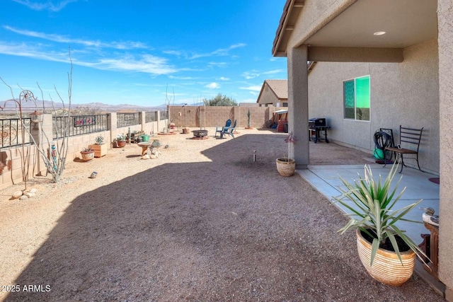 view of yard featuring a fire pit, a patio area, and a fenced backyard