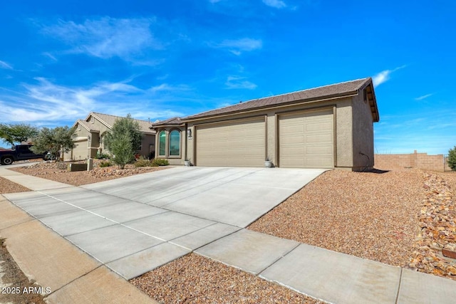 ranch-style house with concrete driveway, an attached garage, and stucco siding