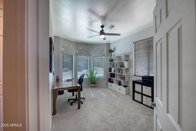 carpeted office with a ceiling fan and a textured ceiling