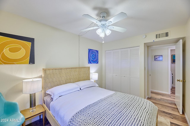 bedroom with ceiling fan, light wood-type flooring, and a closet