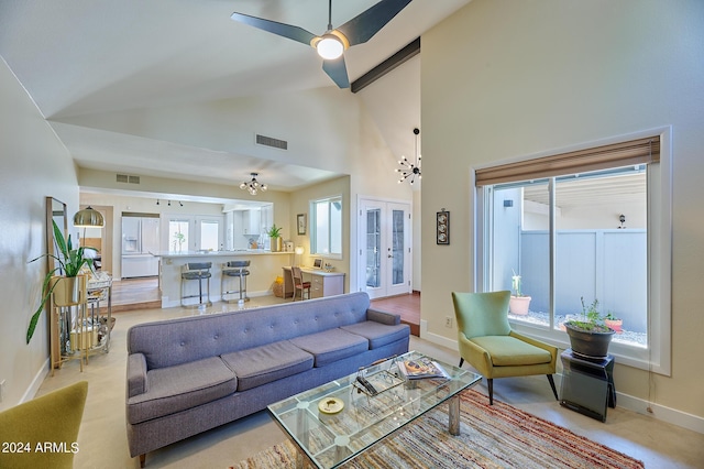 living room with high vaulted ceiling, an inviting chandelier, and french doors