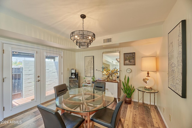 dining area featuring french doors, an inviting chandelier, and light hardwood / wood-style flooring