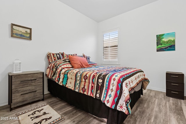 bedroom featuring lofted ceiling and hardwood / wood-style floors