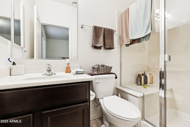 bathroom with vanity, toilet, and a shower with shower door