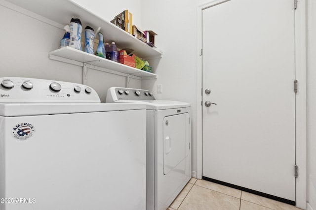 laundry area with light tile patterned floors and washing machine and clothes dryer