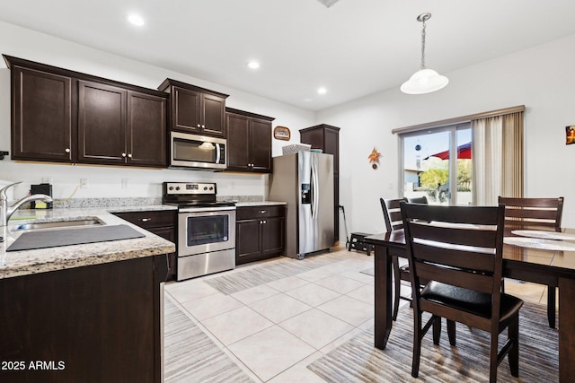 kitchen with appliances with stainless steel finishes, decorative light fixtures, sink, light tile patterned floors, and dark brown cabinetry