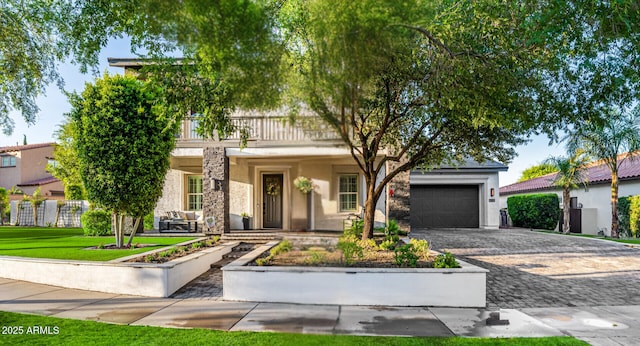 20866 W Werner Pl, Buckeye, AZ 85396 - view of front facade with decorative driveway, stucco siding, a balcony, a garage, and stone siding