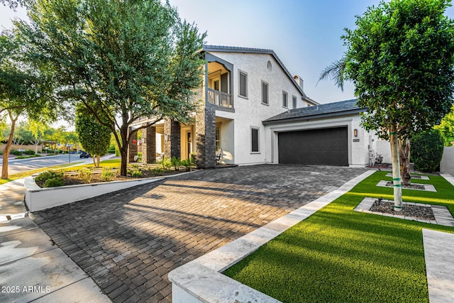 20866 W Werner Pl, Buckeye, AZ 85396 - view of front of house featuring stucco siding, a balcony, an attached garage, decorative driveway, and a front yard