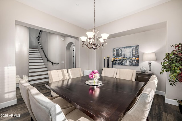 20866 W Werner Pl, Buckeye, AZ 85396 - dining area with arched walkways, dark wood-style flooring, stairs, a chandelier, and baseboards