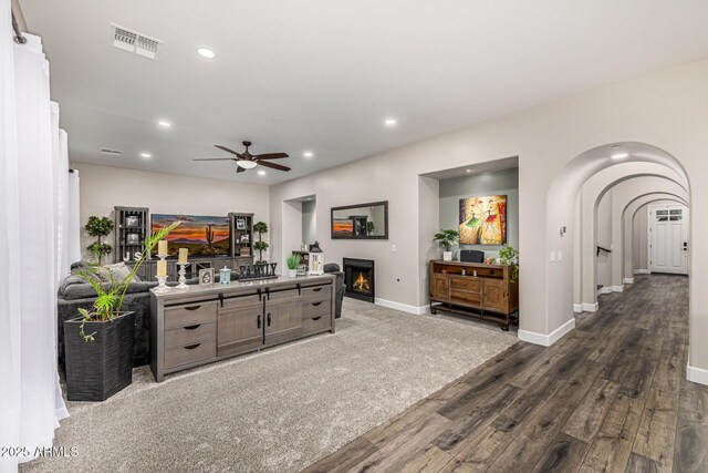 20866 W Werner Pl, Buckeye, AZ 85396 - living room with a warm lit fireplace, baseboards, dark wood-style floors, recessed lighting, and a ceiling fan