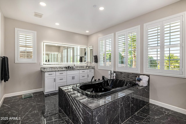 20866 W Werner Pl, Buckeye, AZ 85396 - full bath featuring marble tiled floors, baseboards, recessed lighting, vanity, and a tub with jets