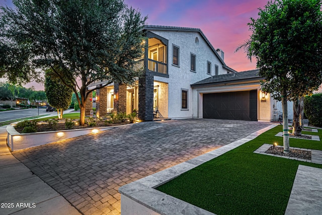 20866 W Werner Pl, Buckeye, AZ 85396 - contemporary house featuring a balcony, a garage, decorative driveway, stucco siding, and a lawn
