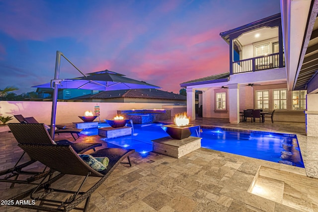 20866 W Werner Pl, Buckeye, AZ 85396 - pool at dusk with a fire pit, a ceiling fan, a patio, and a pool with connected hot tub