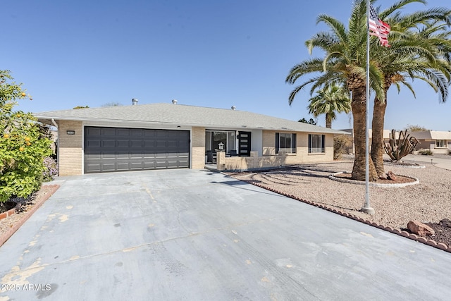 single story home featuring brick siding, an attached garage, and concrete driveway