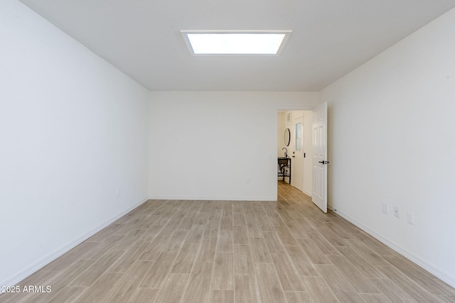 spare room with light wood finished floors and baseboards