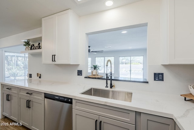 kitchen with a sink, open shelves, light stone counters, stainless steel dishwasher, and recessed lighting