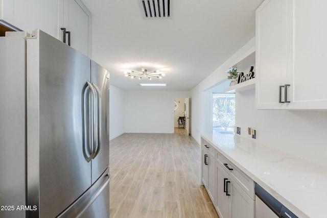 kitchen with visible vents, open shelves, freestanding refrigerator, white cabinets, and light wood-type flooring