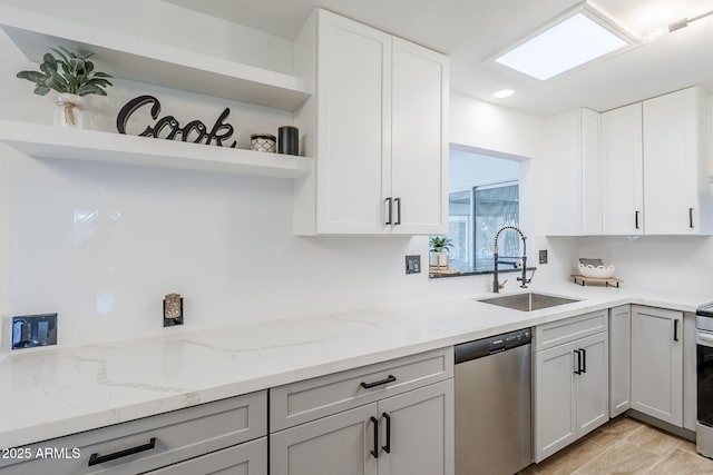 kitchen with light stone countertops, open shelves, a sink, white cabinets, and stainless steel dishwasher