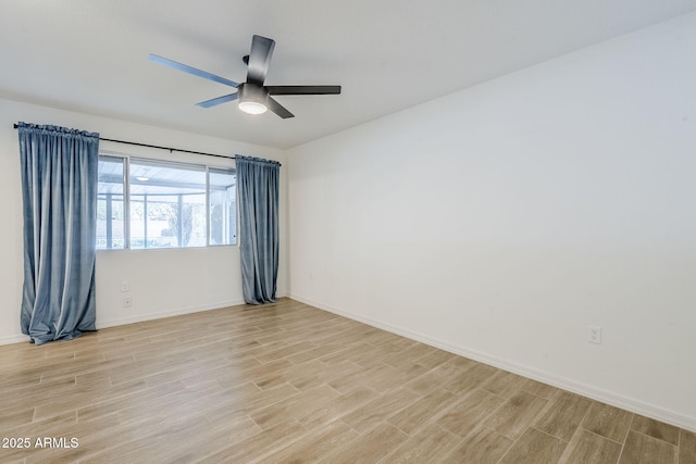 empty room featuring light wood finished floors, ceiling fan, and baseboards