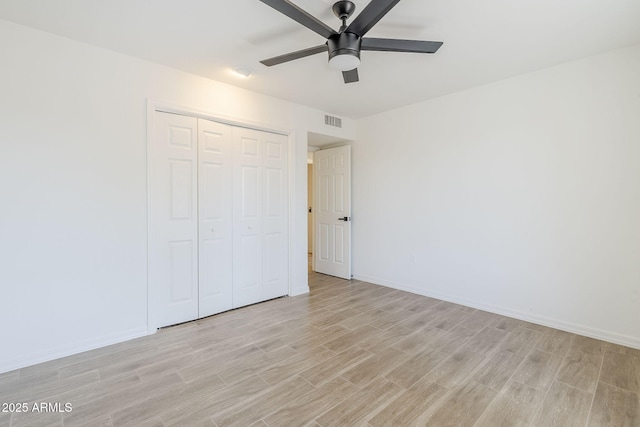 unfurnished bedroom with visible vents, baseboards, a closet, and light wood-style flooring