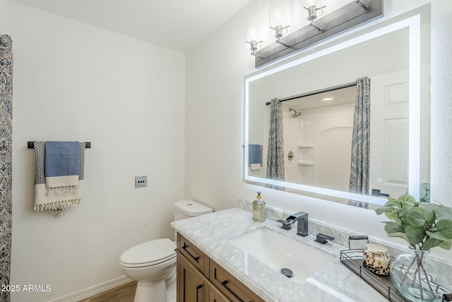 bathroom with baseboards, toilet, a shower with shower curtain, wood finished floors, and vanity