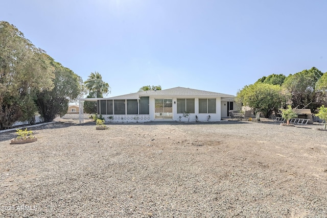 rear view of property featuring a sunroom