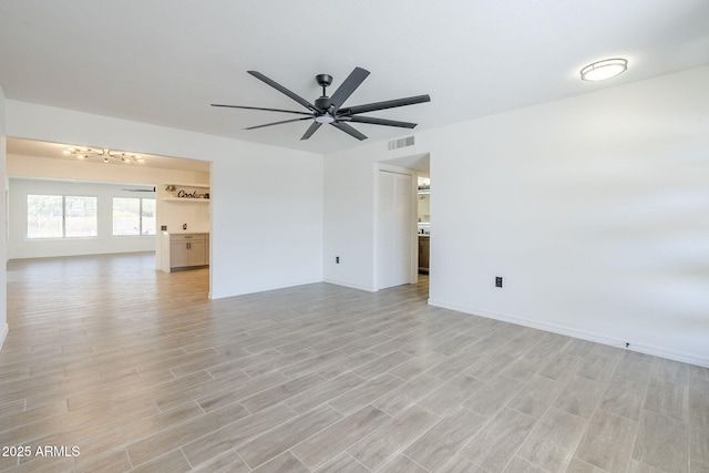 unfurnished living room with visible vents, light wood-style flooring, baseboards, and a ceiling fan