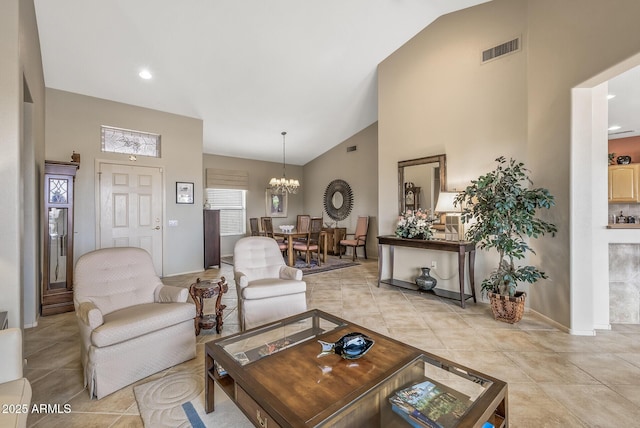 tiled living room with an inviting chandelier and high vaulted ceiling