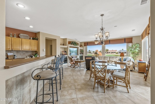 dining area featuring light tile patterned floors, built in features, and a chandelier