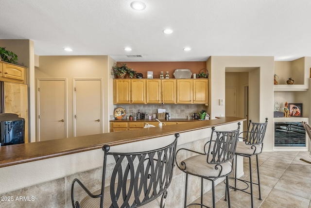 kitchen featuring tasteful backsplash and light brown cabinetry