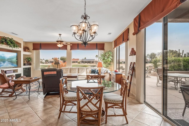 tiled dining room with ceiling fan with notable chandelier