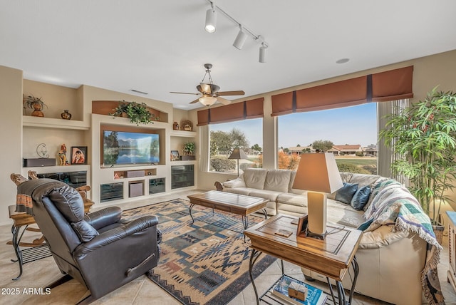 living room featuring rail lighting, built in features, and a wealth of natural light