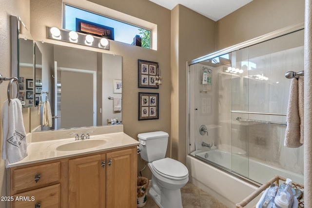 full bathroom featuring enclosed tub / shower combo, vanity, toilet, and tile patterned floors