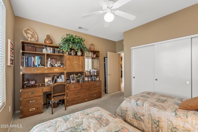 carpeted bedroom featuring a closet and ceiling fan