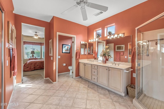 bathroom with ceiling fan, vanity, toilet, and a shower with door